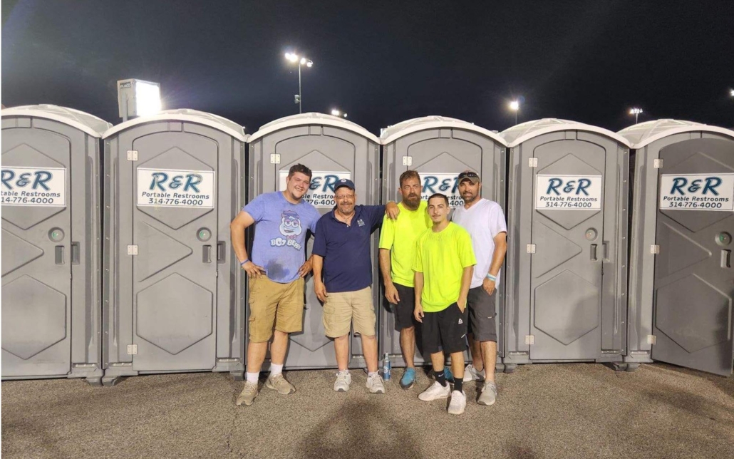 Workers standing in front of portable toilets