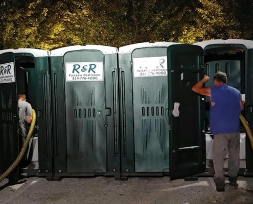 Workers cleaning out portable toilets