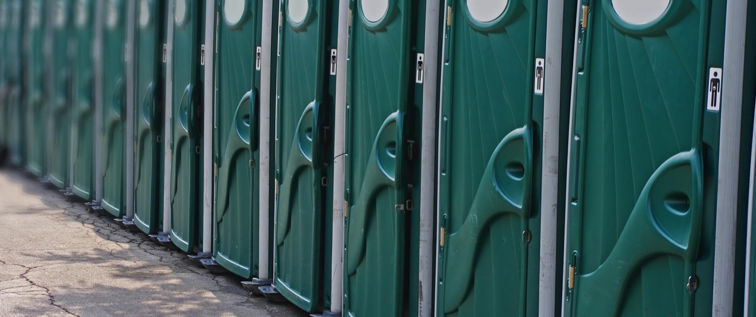 Side view of a row of green portable toilets