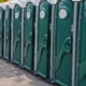 Side view of a row of green portable toilets